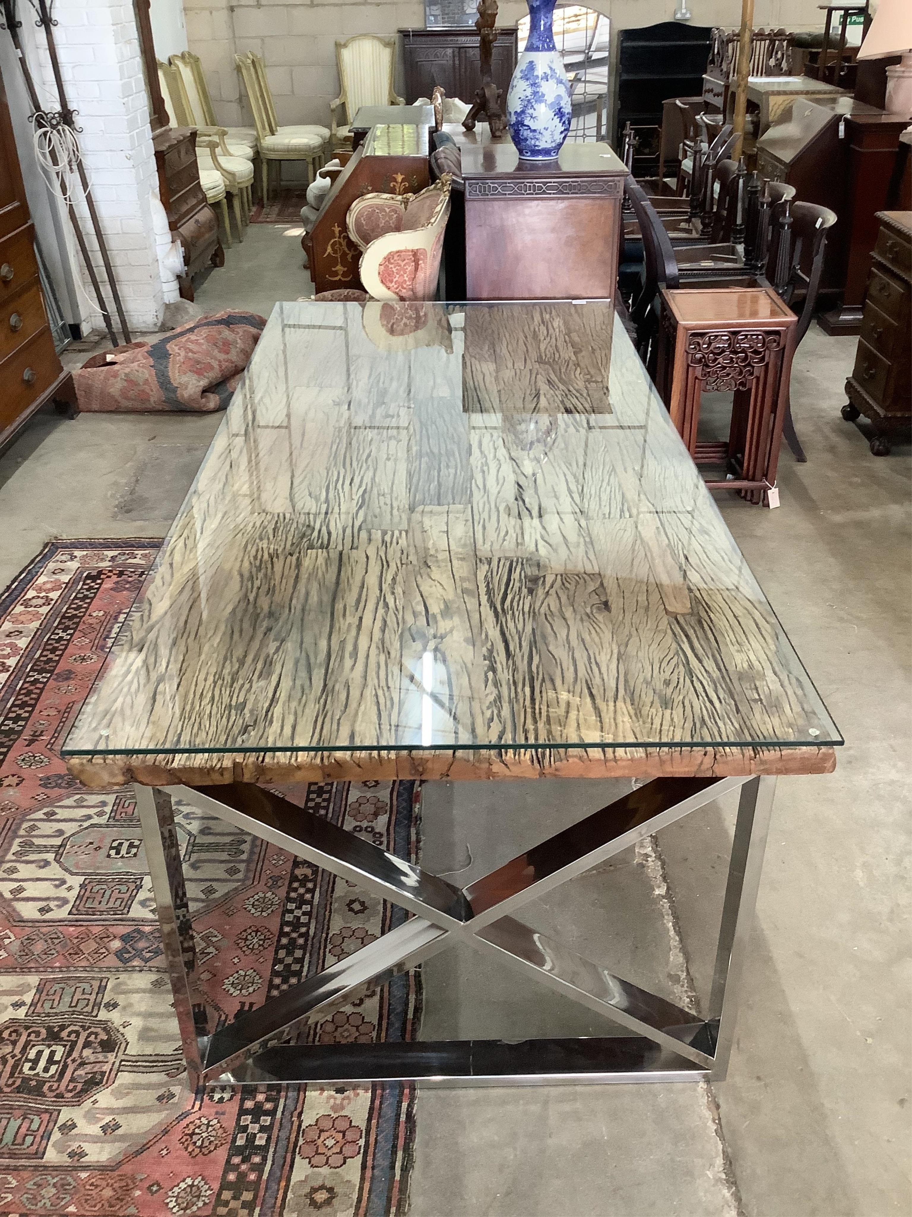 A Contemporary glass top weathered timber and chrome dining table, the top made from old train rail track woods, width 221cm, depth 102cm, height 77cm, and a set of six upholstered dining chairs. Condition - good